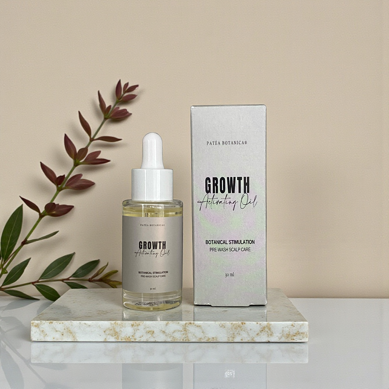 Patea Growth Activating Oil bottle and packaging on a marble surface with a plant in the background