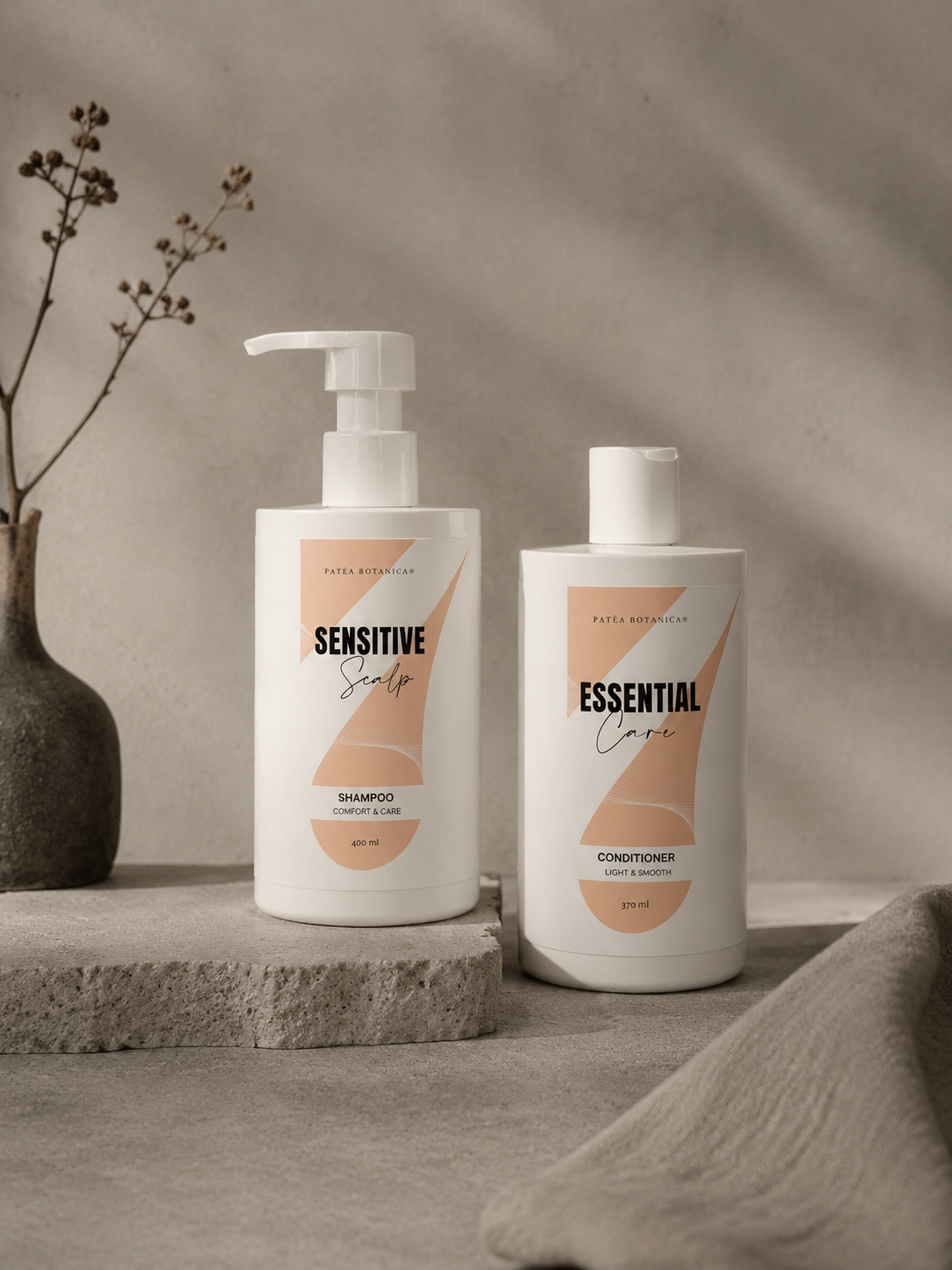 Two bottles of 'Sensitive' and 'Essential' Patea Botanica shampoo and conditioner on a neutral background.